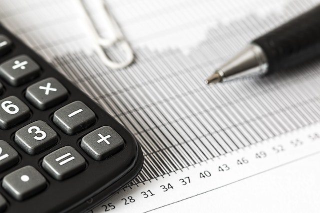 Calculator and pen on a table.