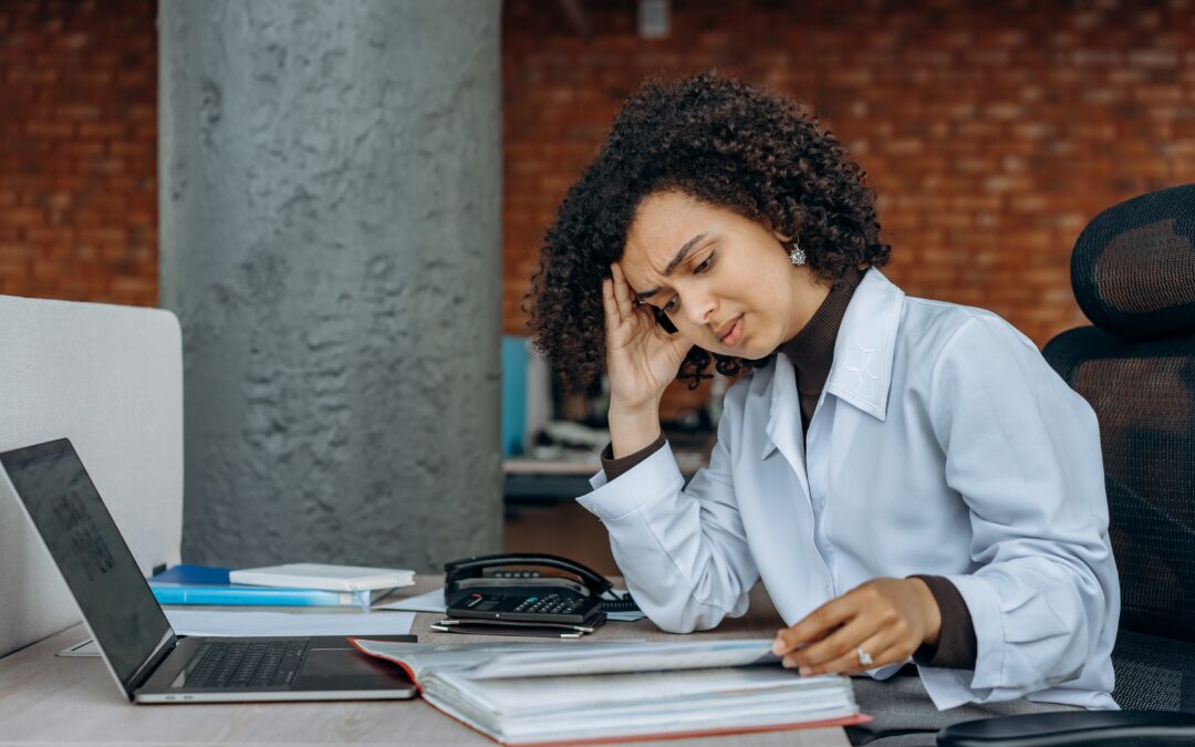 A woman tiredly looks over documents.